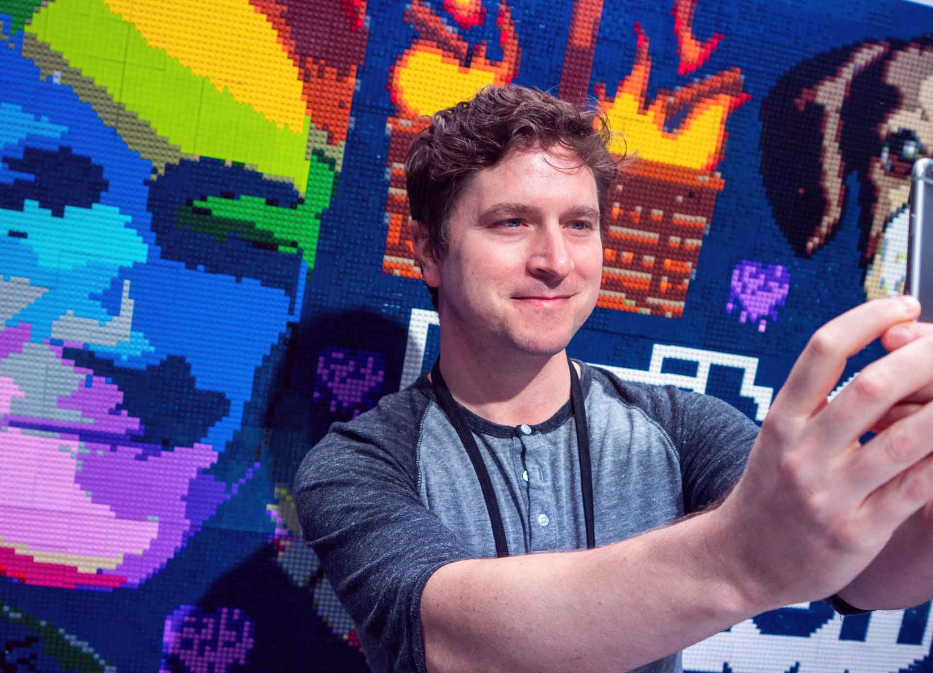 The real life Kappa poses in front of a mural of his popular emote.